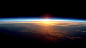 A high resolution photograph of Sunrise viewed from space over the Earth's horizon.